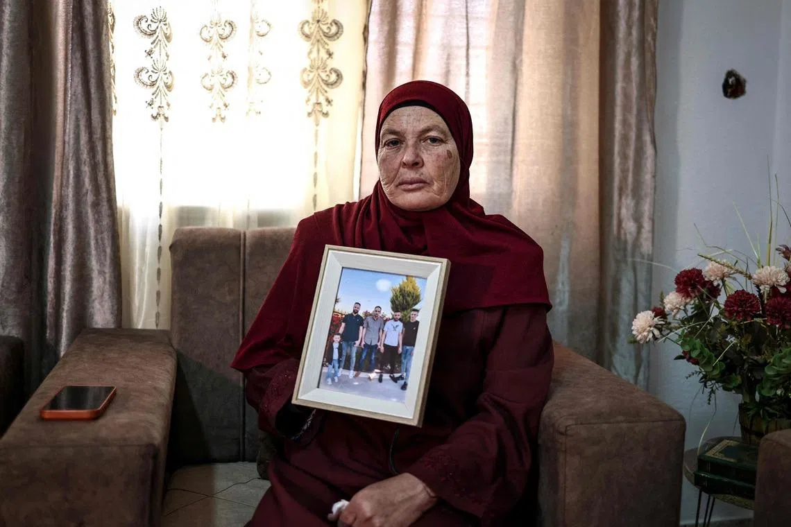 Ms Milaya Hamayel poses with a photo of her son Thaer, who was killed during a violent Israeli settlers’ attack.