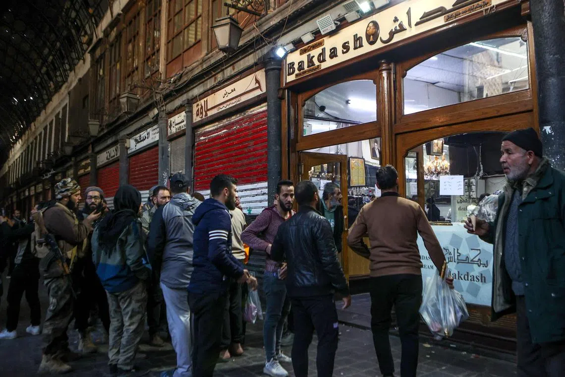 People queueing to buy ice cream at the Hamidiyeh Souq in the Syrian capital Damascus on Dec 9.