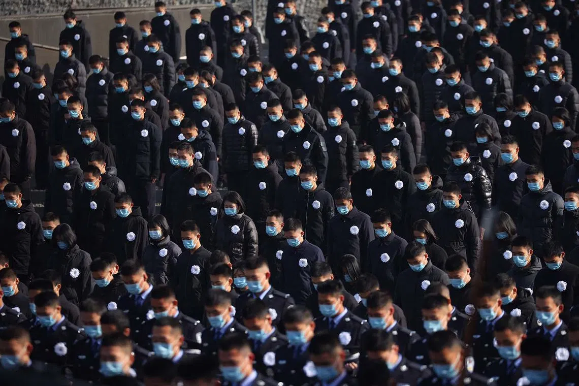 TOPSHOT - People stand during a silent tribute during a ceremony at the Memorial Hall of the Victims in Nanjing Massacre by Japanese Invaders on the annual national day of remembrance to commemorate the 85th anniversary of the Nanjing massacre in Nanjing, in China's eastern Jiangsu province on December 13, 2022. (Photo by CNS / AFP) / China OUT