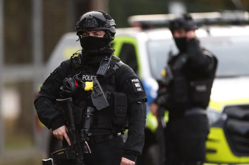 An armed police officer standing guard outside the perimeter of the RAF Fairford airbase, after the arrest of several men on Sept 28.
