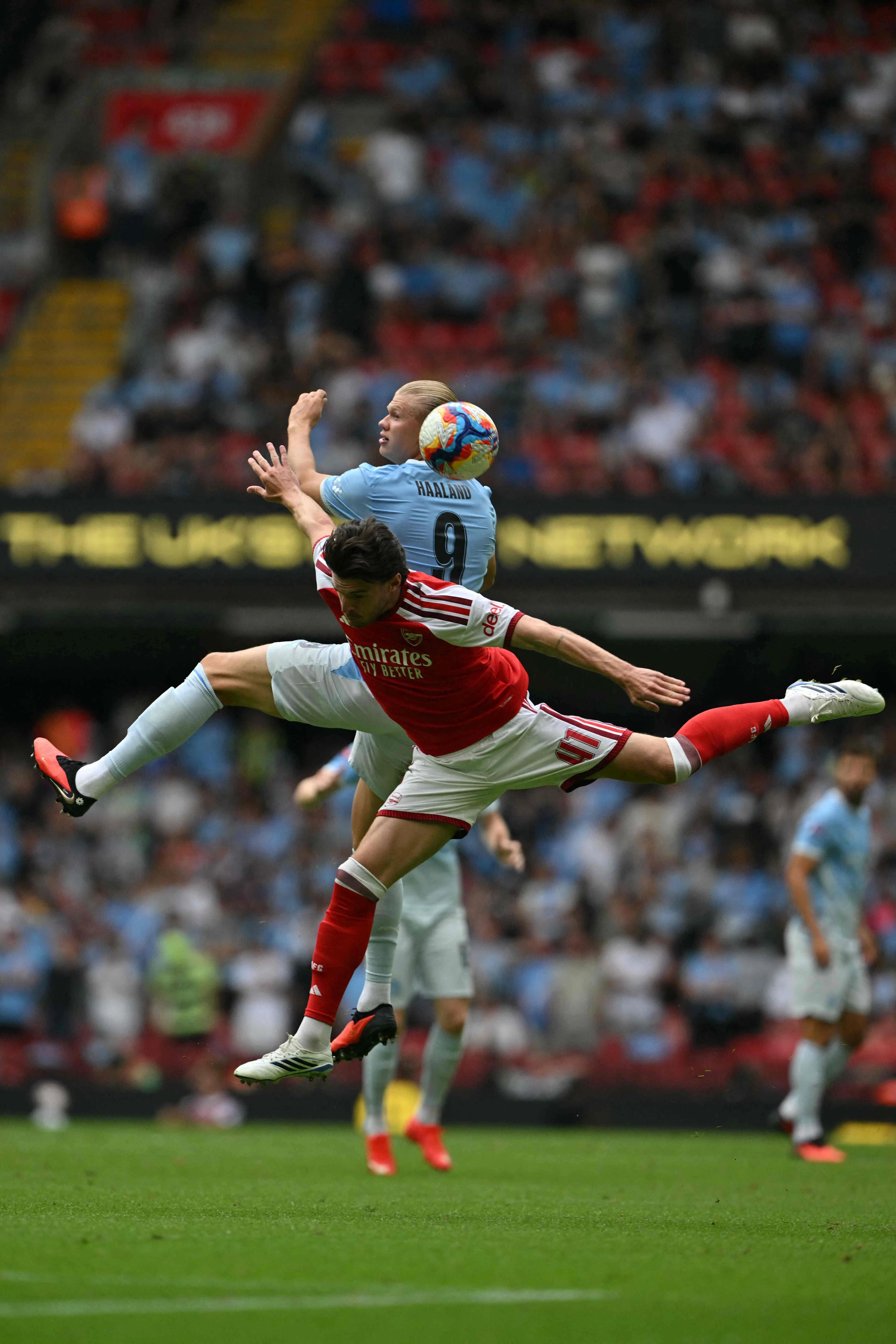 Arsenal midfielder Declan Rice vying with Manchester City striker Erling Haaland.