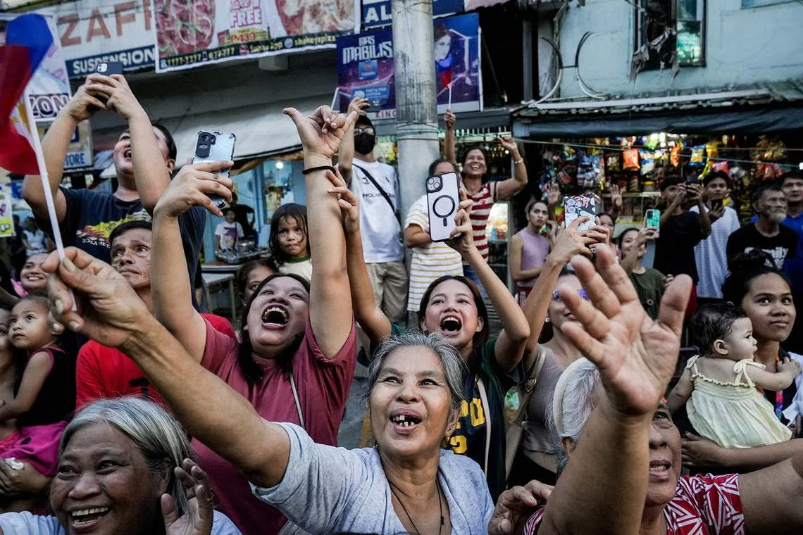 People cheering as they take part in a welcoming parade for Filipino gymnast Carlos Edriel Yulo, who won gold medals in men's floor exercise and men's vault at the Olympics, along with other Filipino athletes who competed at the Paris 2024 Olympics, in Manila, Philippines, Aug 14, 2024. 