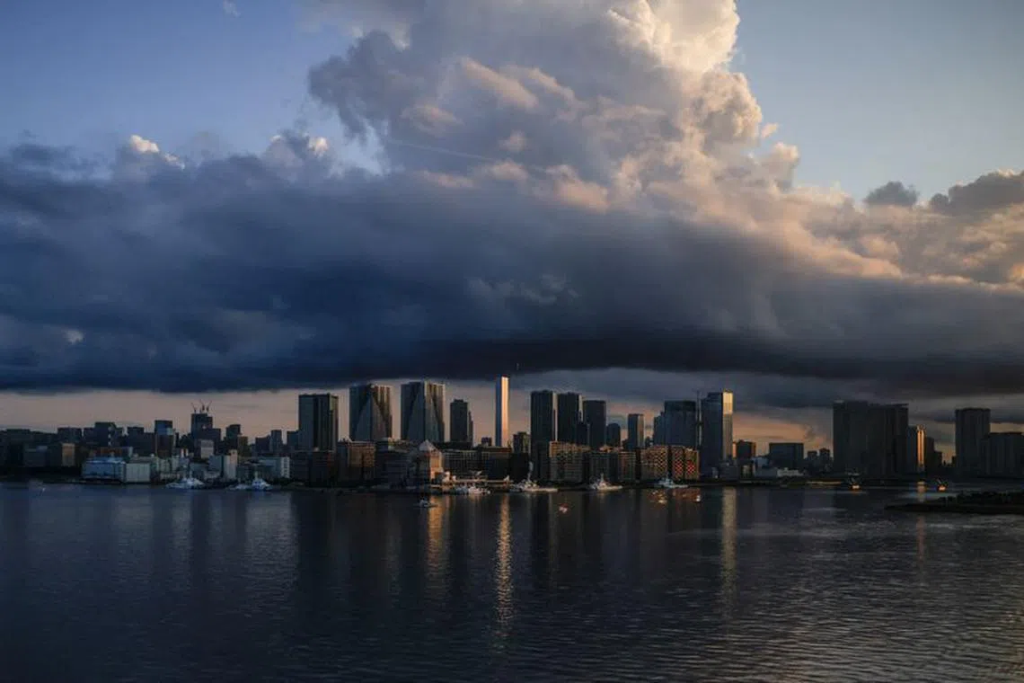 FILE PHOTO: City skyline and harbour are seen at sunrise from a quarantine bus window during the Tokyo 2020 Olympic Games in Tokyo, Japan July 24, 2021. REUTERS/Maxim Shemetov/File Photo
