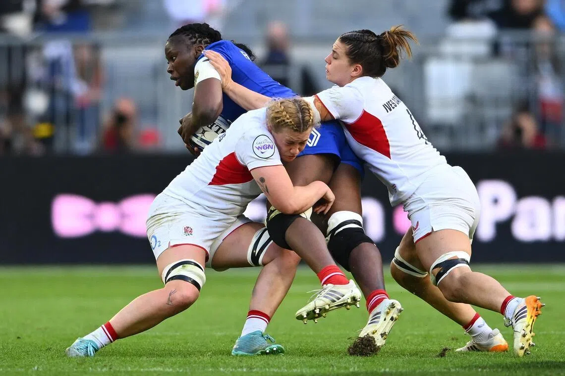 France's second row Madoussou Fall Raclot is tackled by England's second row Delaney Burns (left) and Lilli Ives Campion  in their Women's Six Nations international rugby union match at the Stade Atlantique in Bordeaux on May 17, 2026.