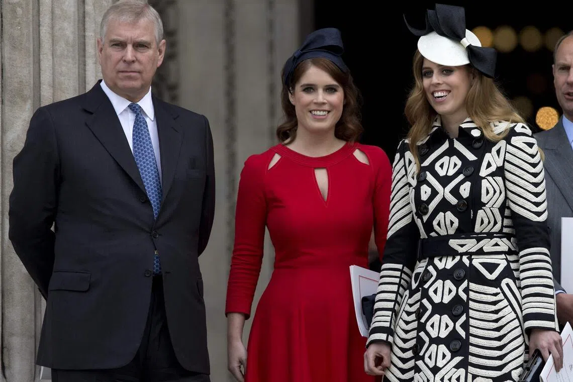 Britain's former prince Andrew (left) with his daughters, Princess Eugenie (centre) and Princess Beatrice (right).  