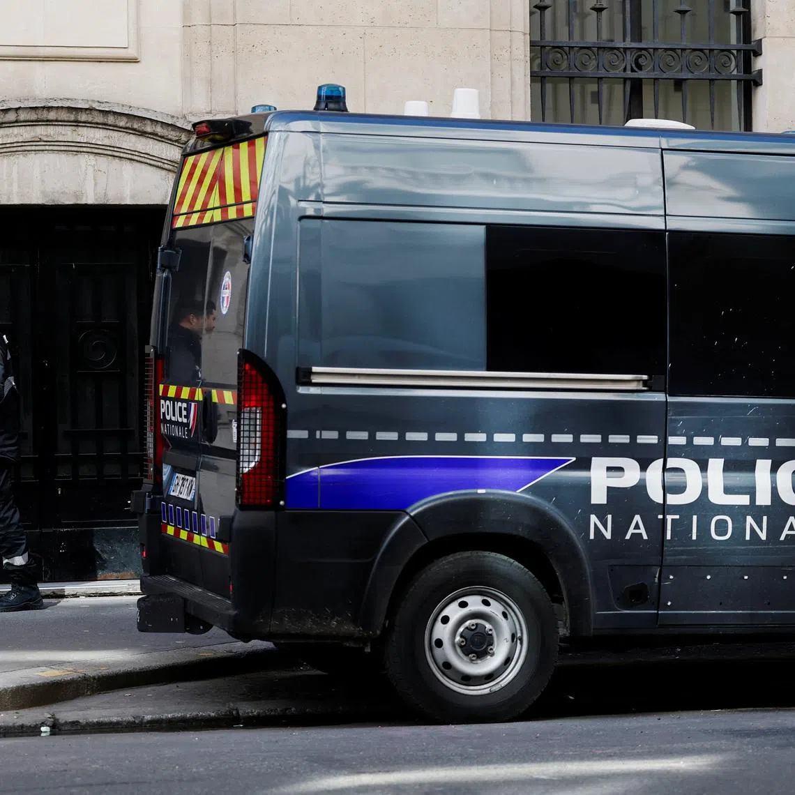 A private security member stands next to a police van outside Bank of America’s Paris offices, after French anti-terrorism prosecutors opened an investigation into attempted destruction by fire or other dangerous means in Paris, France, March 30, 2026. REUTERS/Benoit Tessier