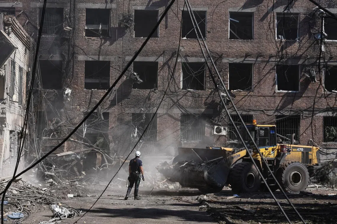 FILE PHOTO: A man stands next to a vehicle as rescuers work at a site of an apartment building hit by a Russian missile strike, amid Russia's attack on Ukraine, in Kryvyi Rih, Dnipropetrovsk region, Ukraine July 8, 2024. REUTERS/Mykola Synelnykov/File Photo