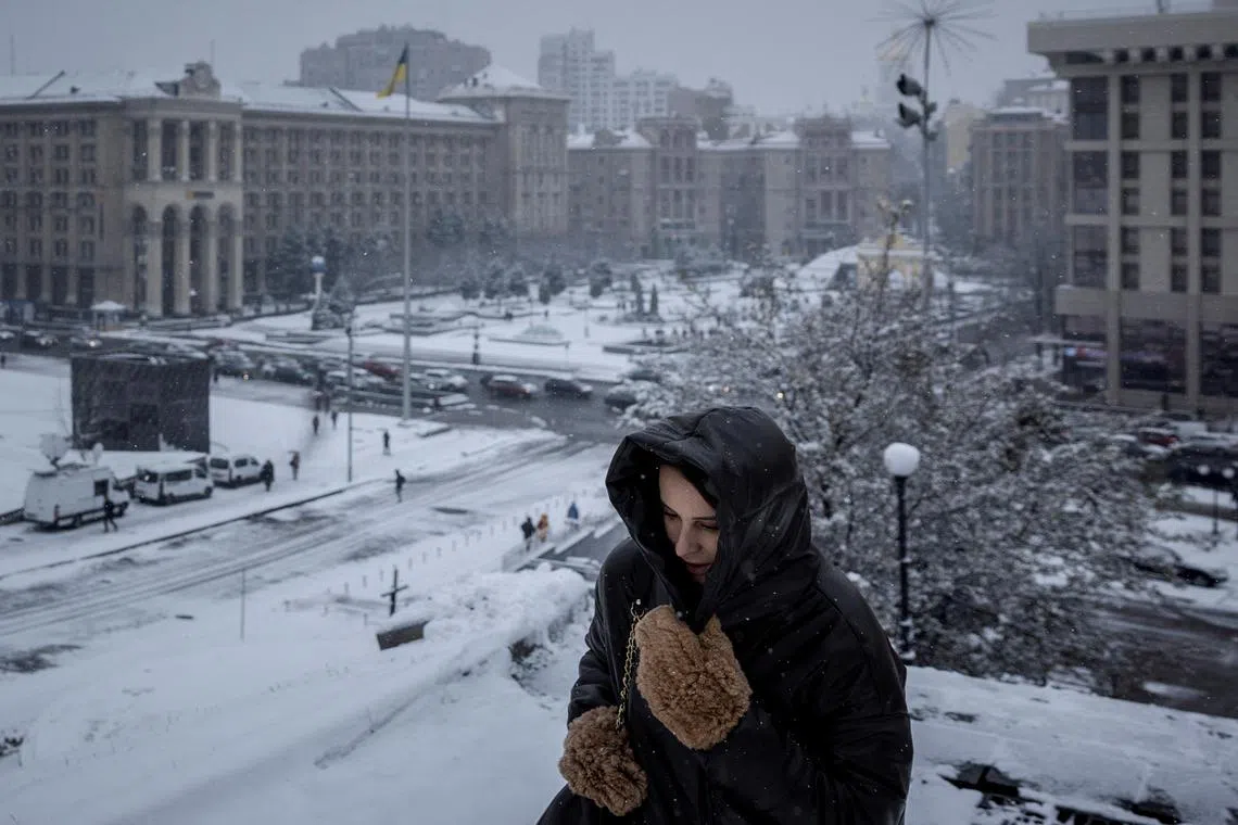 A woman walking near Independence Square (Maidan Nezalezhnosti) on the first snowy day of the year in Kyiv, amid Russia’s attack on Ukraine, Nov 22, 2023.  