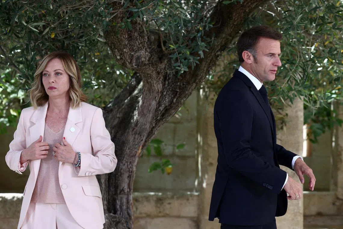 FILE PHOTO: French President Emmanuel Macron walks next to Italy's Prime Minister Giorgia Meloni on the first day of the G7 summit, at the Borgo Egnazia resort, in Savelletri, Italy June 13, 2024. REUTERS/Guglielmo Mangiapane/File Photo
