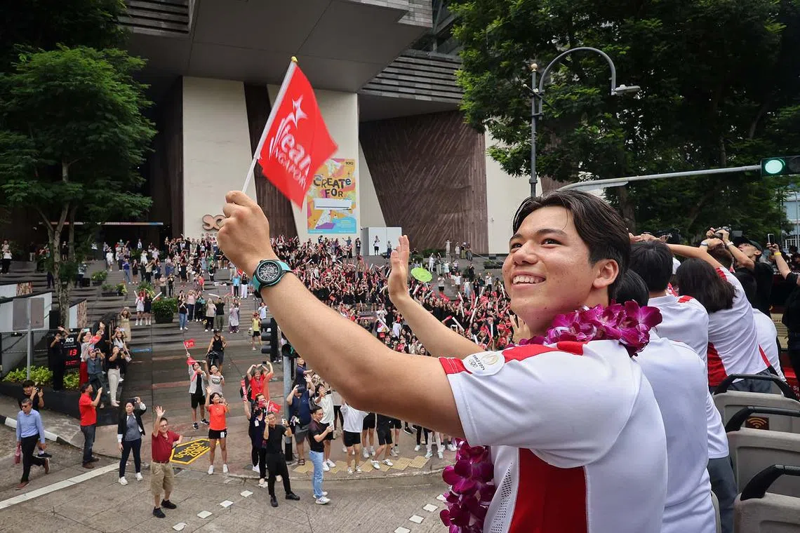 Olympic bronze medallist and kitefoiler Maximilian Maeder waving to supporters as the One Team Singapore celebratory parade passes by School of the Arts (SOTA) on Aug 14, 2024.