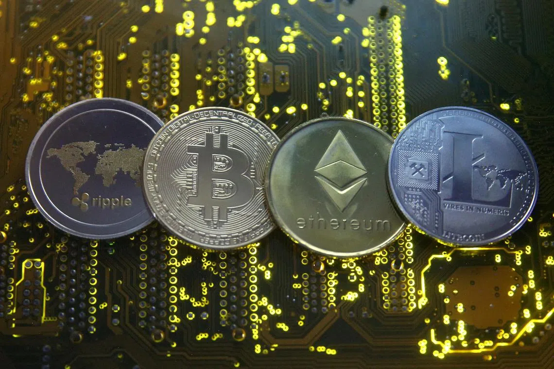Representations of the Ripple, Bitcoin, Etherum and Litecoin virtual currencies are seen on a PC motherboard in this illustration picture, February 14, 2018. REUTERS/Dado Ruvic//File Photo