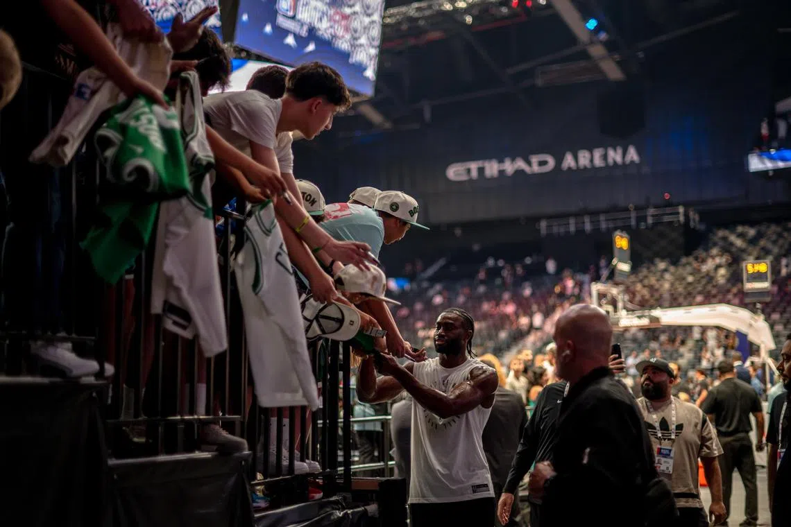 Jaylen Brown of the Boston Celtics autographs items for fans before a pre-season game against the Denver Nuggets at Etihad Arena in Abu Dhabi.
