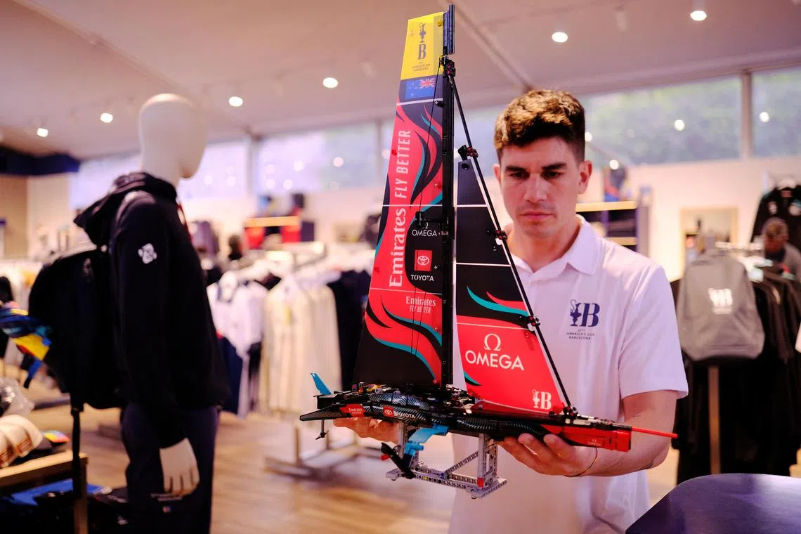 A fan is seen holding an America's Cup crews Lego model of Emirates Team New Zealand's AC75.