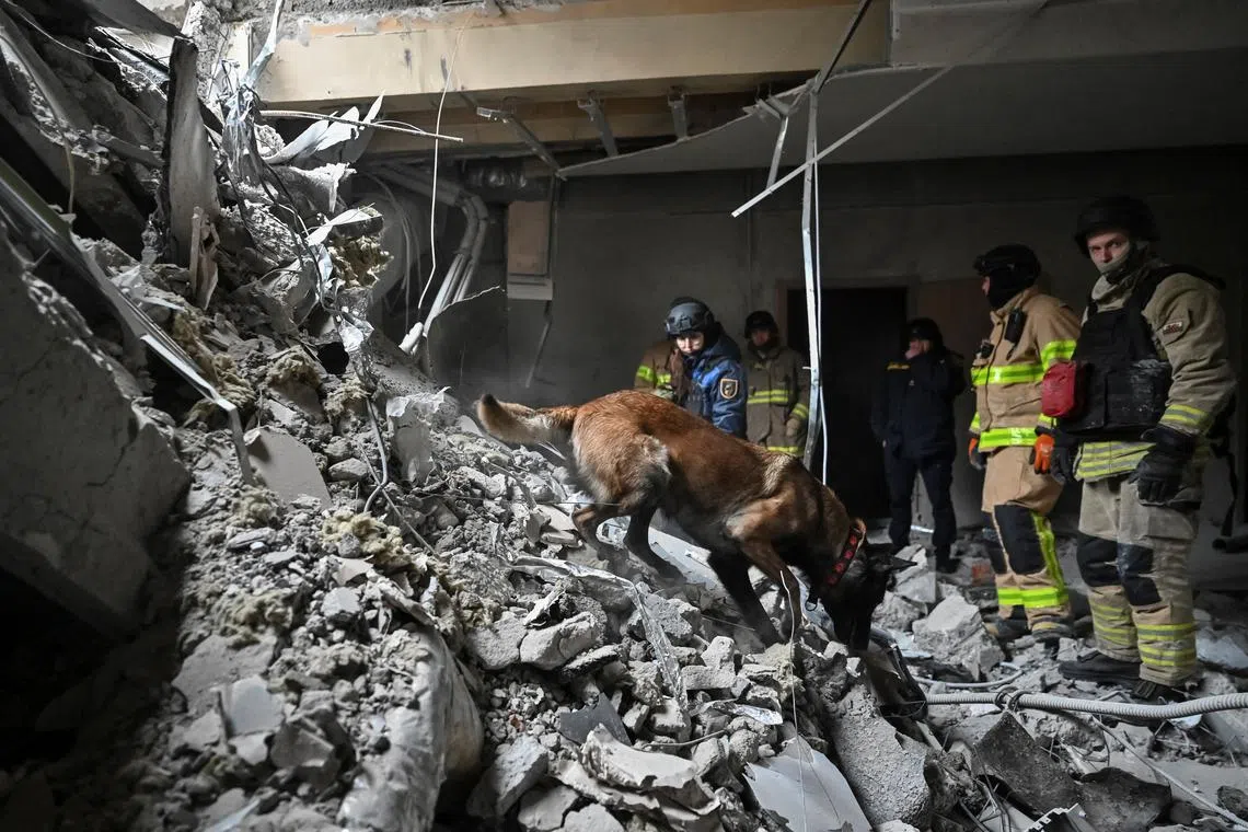Rescuers work with a dog at the site where a building was heavily damaged by yesterday's Russian missile strike, amid Russia's attack on Ukraine, in Zaporizhzhia, Ukraine December 11, 2024. REUTERS/Stringer