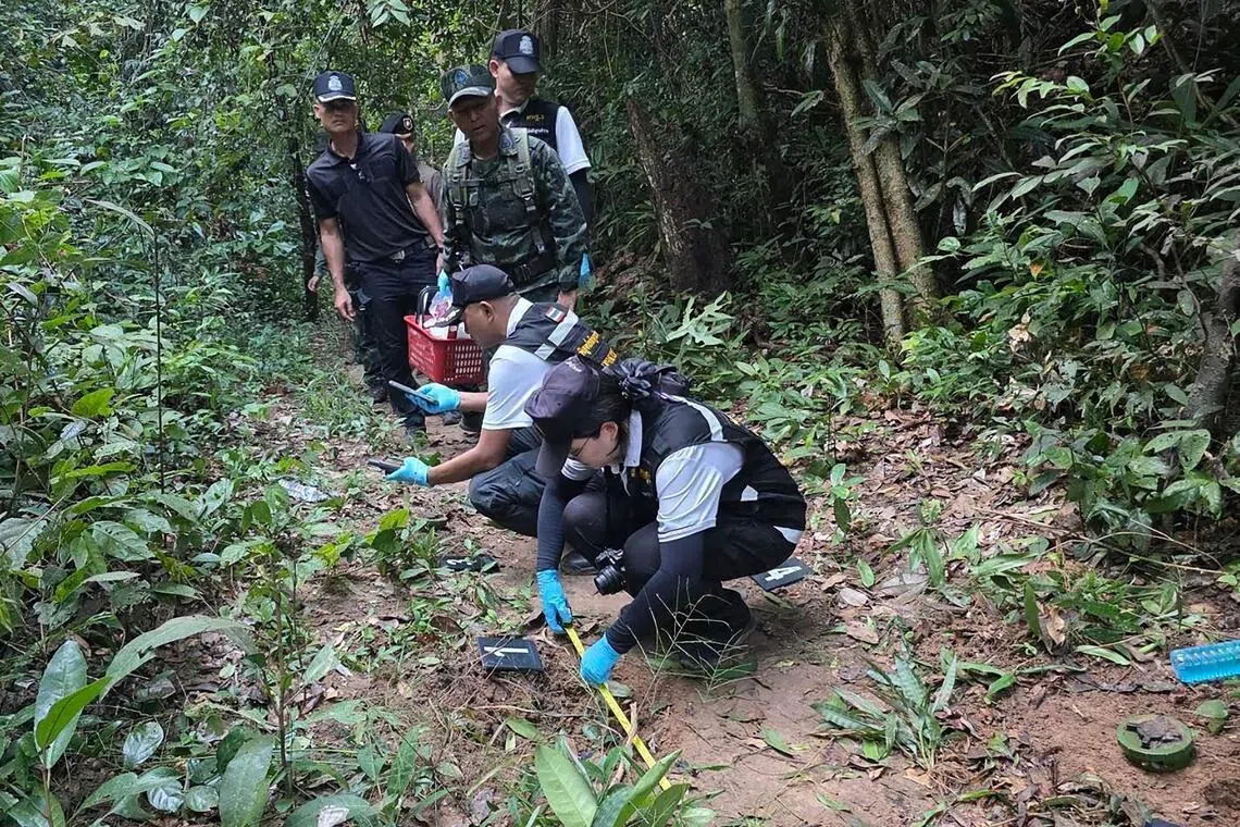 Thai police and army personnel examining fragments of a landmine in Sisasket province along the Cambodia-Thailand border.  