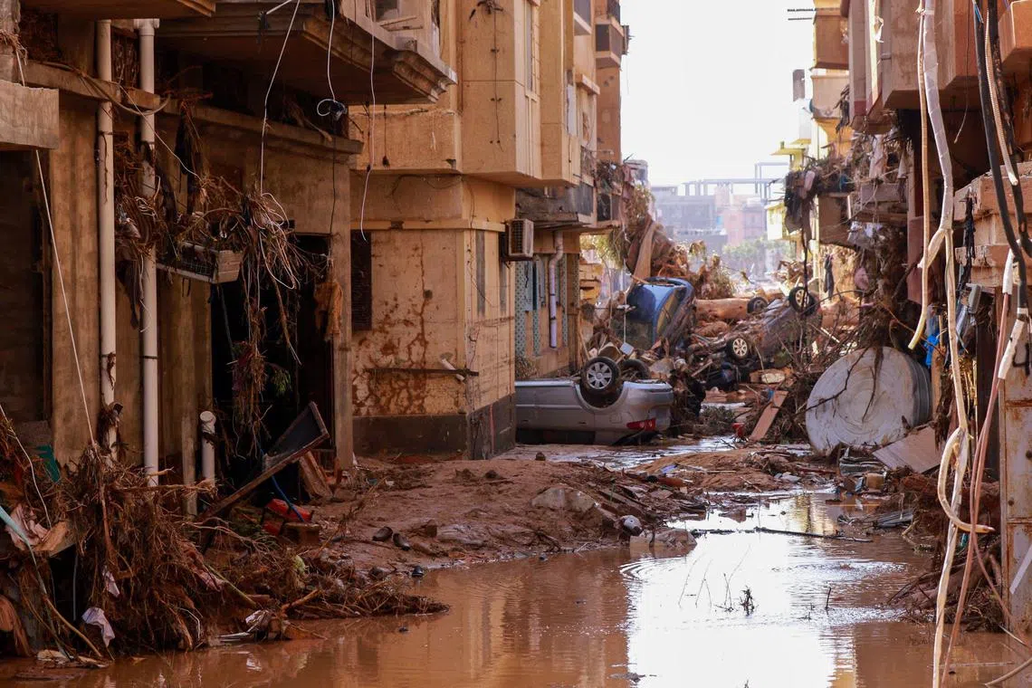 Overturned cars lay among other debris caused by flash floods in Derna, eastern Libya, on September 11, 2023. The death toll from freak floods in eastern Libya is expected to soar dramatically, with 10,000 people reported missing, the Red Cross warned on September 12. Officials in Libya have said at least 150 people were killed in the sudden flooding on Sunday afternoon after storm Daniel swept the Mediterranean, lashing Bulgaria, Greece and Turkey. (Photo by AFP)