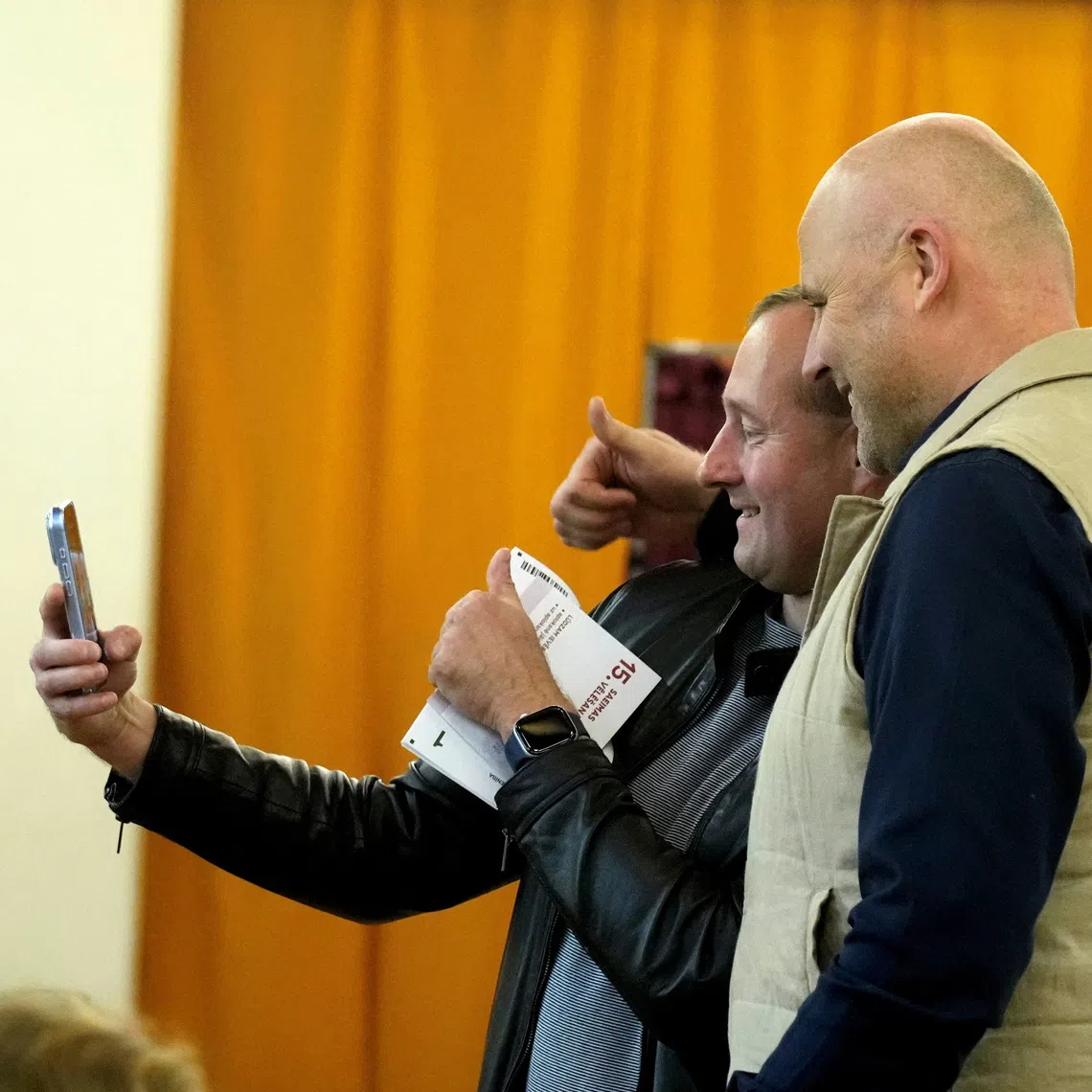 Latvian Prime Minister Andris Kulbergs takes a selfie with a voter during general election in Riga, Latvia, October 3, 2026. REUTERS/Ints Kalnins
