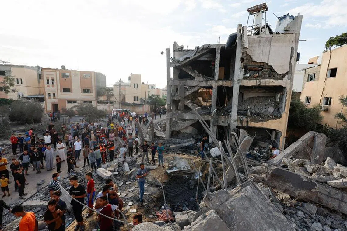 Palestinians search for casualties under the rubble of a building destroyed by Israeli strikes in Khan Younis in the southern Gaza Strip, October 17, 2023. REUTERS/Mohammed Salem