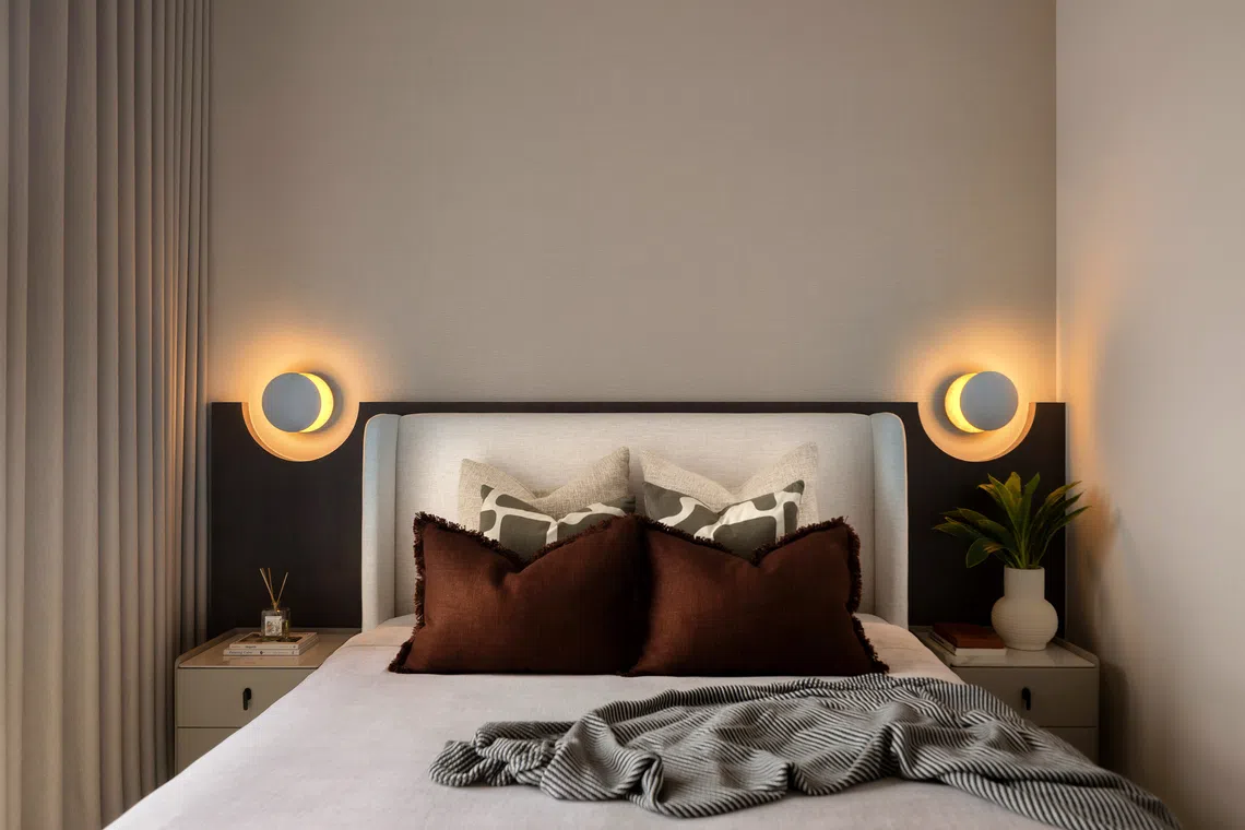 The custom headboard in the master bedroom has cutouts for wall-mounted lamps.