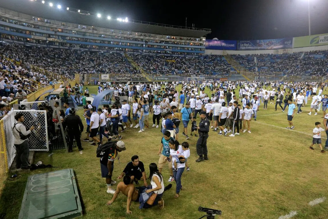 Supporters are helped by others following a stampede during a football match at Cuscatlan stadium in San Salvador, on May 20.