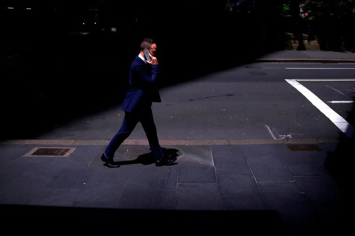 FILE PHOTO: A businessman talks on his Apple iPhone as he walks along a street in the central business district (CBD) of Sydney in Australia, October 24, 2017.     REUTERS/David Gray/File Photo