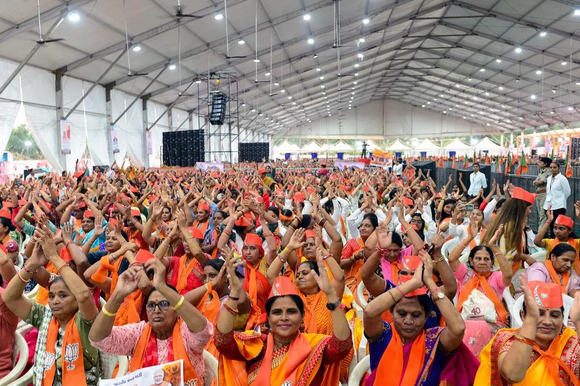 TOPSHOT - Bhartiya Janta Party (BJP) supporters cheer as they welcome Indian Prime Minister Narendra Modi during a BJP gathering of women to address the recently passed women’s reservation bill, in Ahmedabad on September 26, 2023. (Photo by SAM PANTHAKY / AFP)