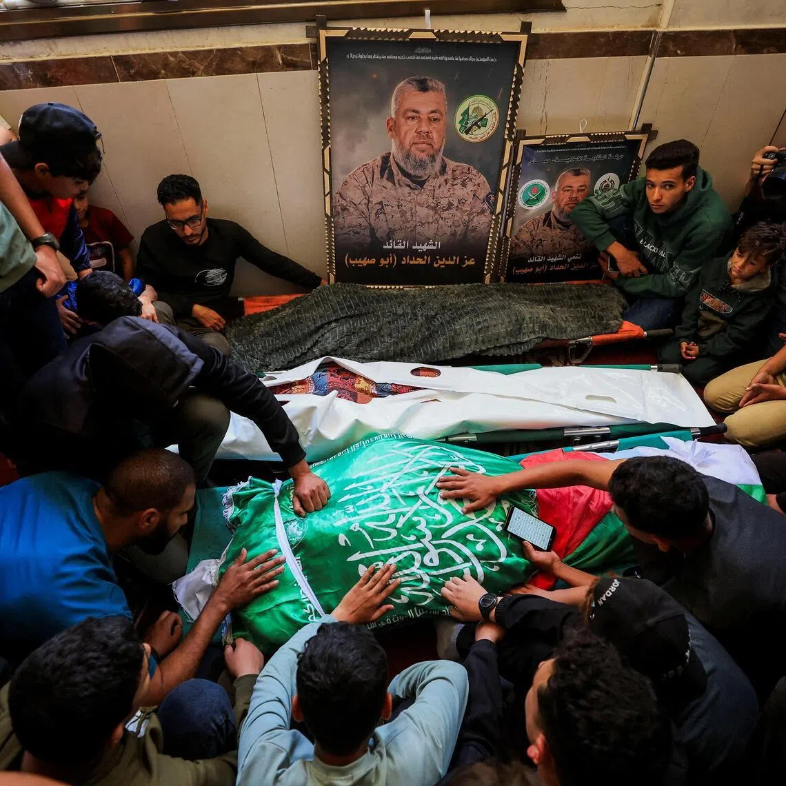 People gather around bodies identified by mourners as Hamas' military wing commander Izz al-Din al-Haddad, his wife and his daughter, who were killed in an Israeli strike on May 15.  