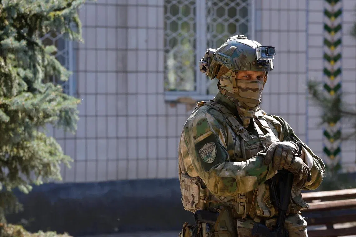 A Russian soldier standing guard outside a school in a Russian-controlled area of Ukraine on Sept 23.