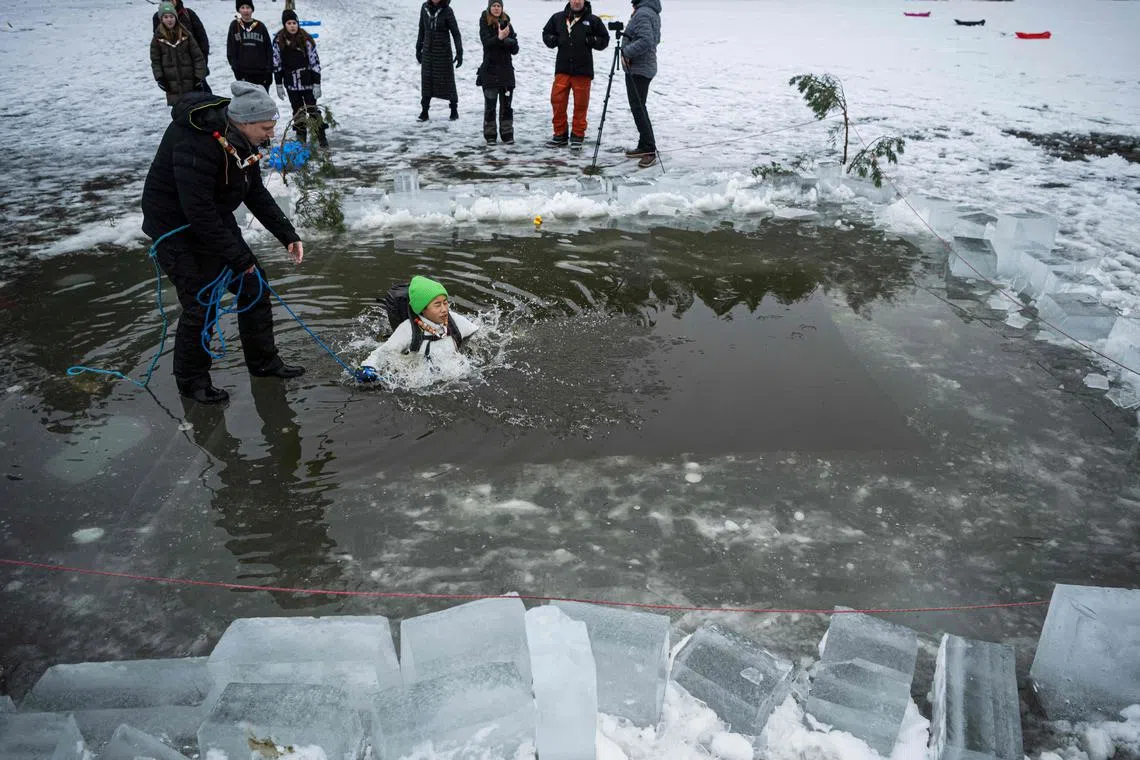 Fifth-grade students from Vaxmora School in Sollentuna participating in an exercise teaching them how to react when falling into hole in the ice, on Feb 7, 2023, In Sollentuna, north of Stockholm.  Forty pupils are taking part in an "isvaksovning" ("hole-in-the-ice exercise"), part of their school's physical education class to learn what to do if they ever fall through the ice on one of Sweden's many lakes or out in the archipelago.