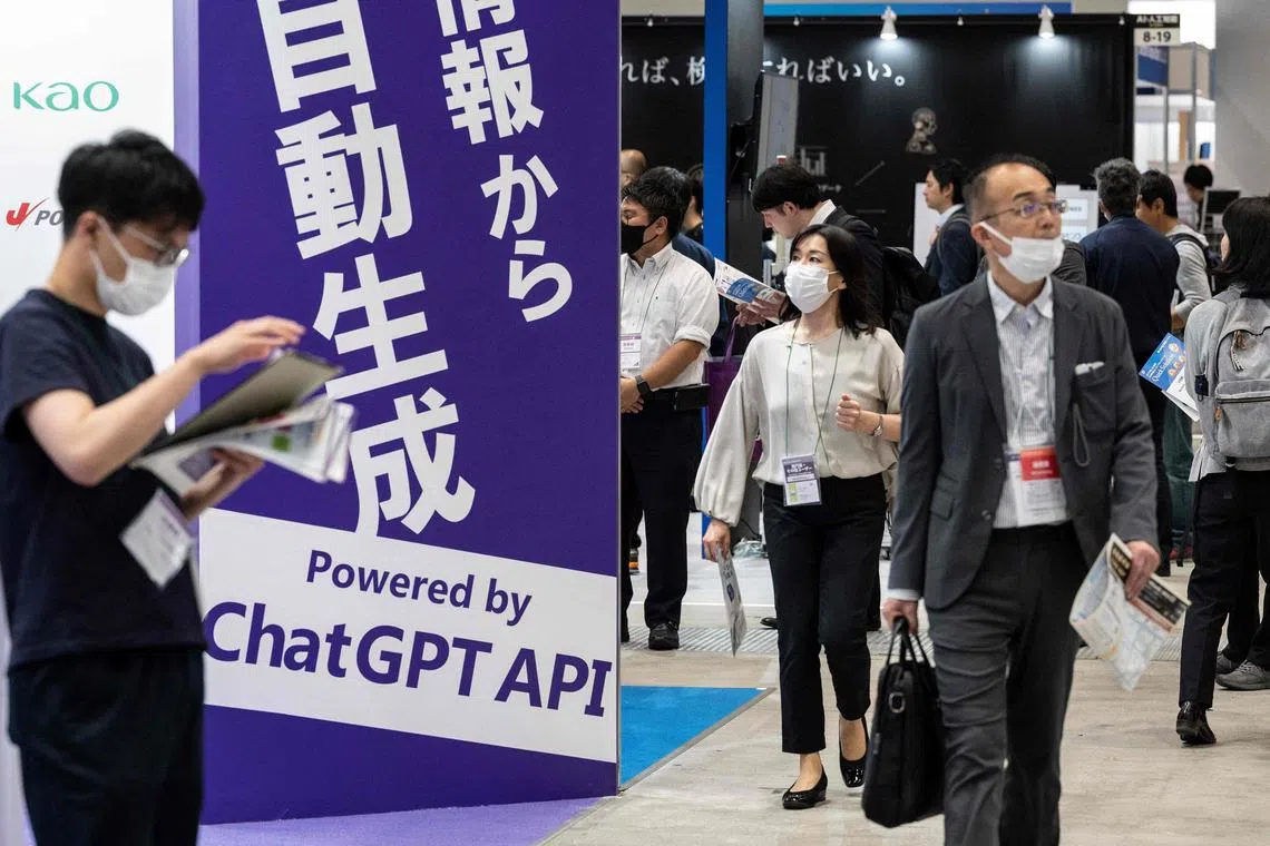This file photo taken on May 10, 2023 shows visitors walking past a sign promoting ChatGPT at the three-day 7th AI Expo, Japan's largest trade show for artificial intelligence technology companies.