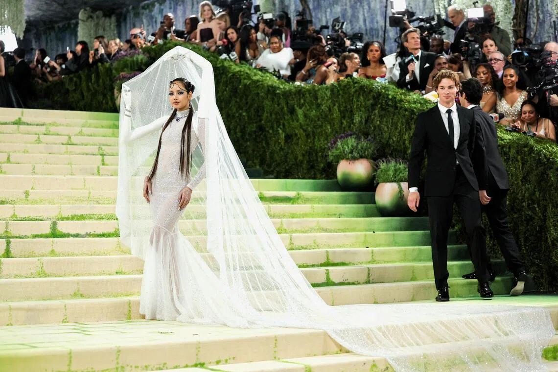 Lisa’s gown featured two extra arms that held up a dramatic veil over her head.