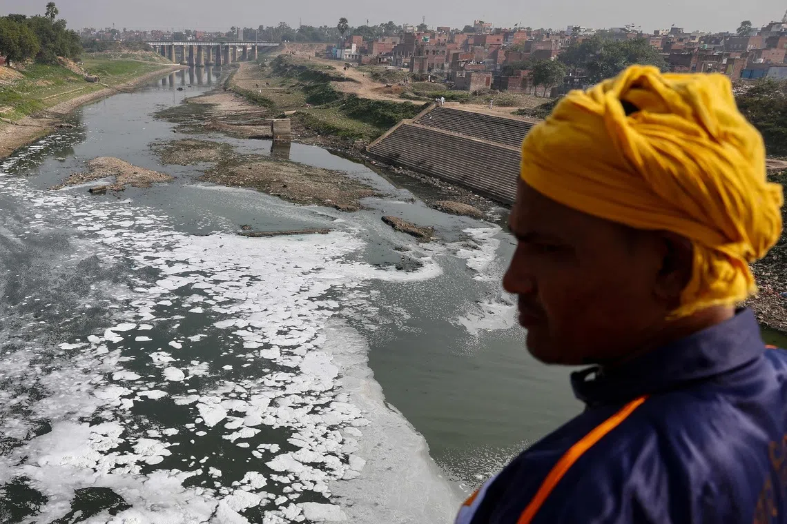 A man near the polluted Varuna River laden with toxic foam in Varanasi, India, on Dec 1, 2025. 
