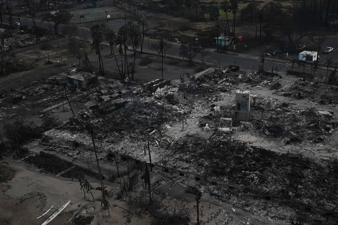 An aerial image shows a destroyed building on Front Street directly north of Lahaina Shores Beach Resort amongst destroyed homes and buildings burned to the ground in the historic Lahaina Town in the aftermath of wildfires in western Maui in Lahaina, Hawaii on August 10, 2023. Embattled officials in Hawaii who have been criticized for the lack of warnings as a deadly wildfire ripped through a town insisted on August 16 that sounding emergency sirens would not have saved lives. At least 110 people died when the inferno levelled Lahaina last week on the island of Maui, with some residents not aware their town was at risk until they saw flames for themselves. (Photo by Patrick T. Fallon / AFP)