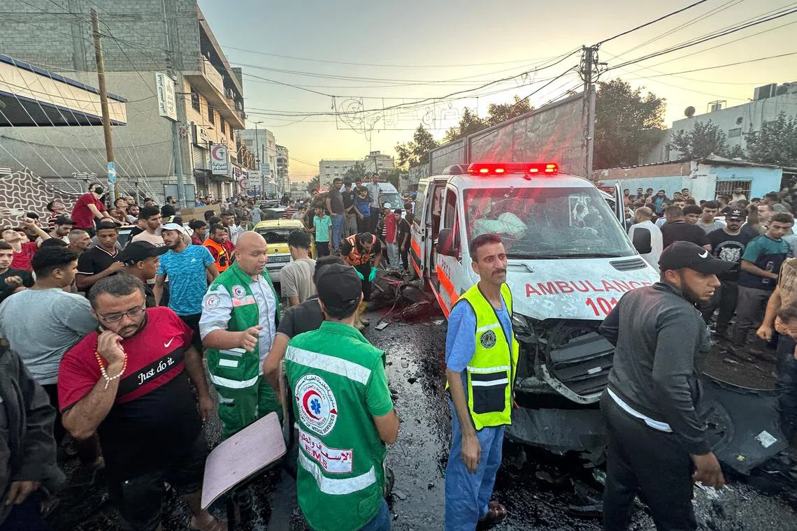 People gather around an ambulance damaged in a reported Israeli strike in front of Al-Shifa hospital in Gaza City, on Nov 3.