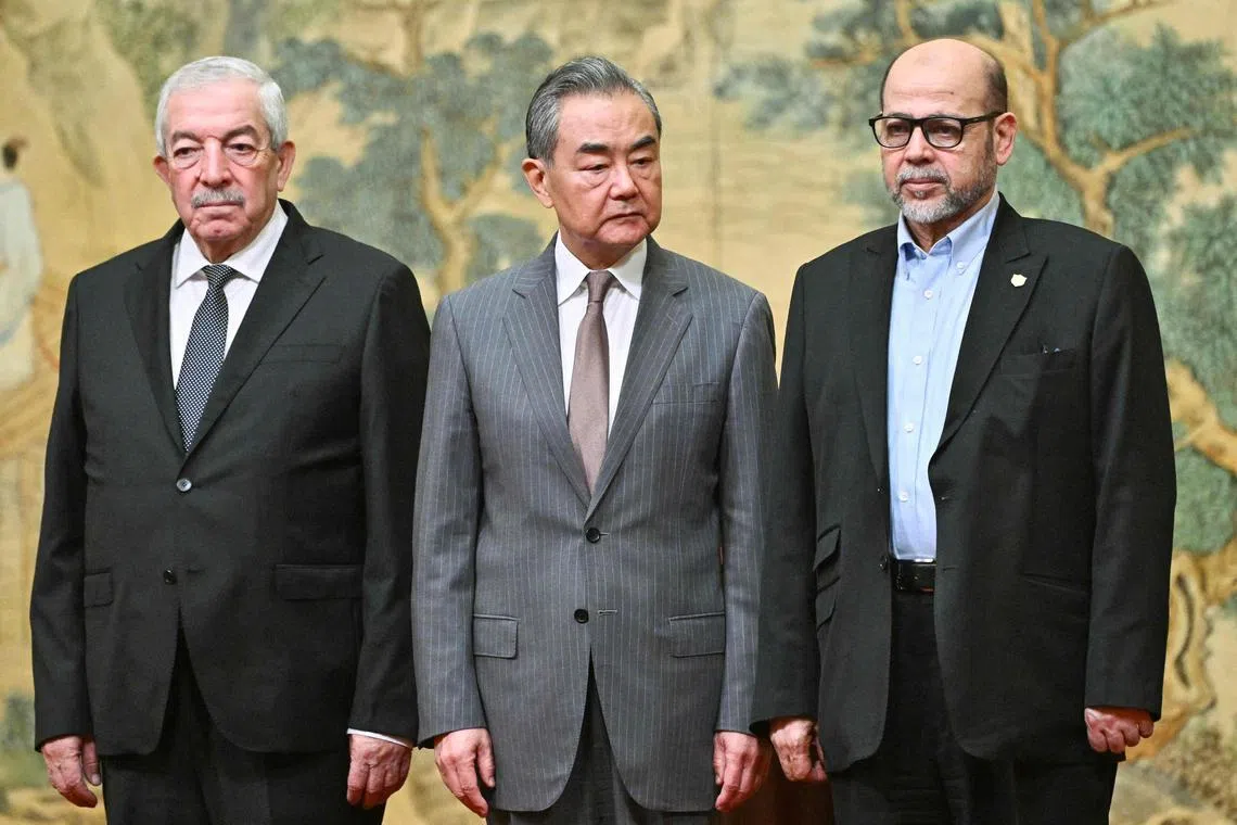 Chinese Foreign Minister Wang Yi (centre) with senior Hamas official Moussa Abu Marzouk (right) and Fatah envoy Mahmud al-Aloul in Beijing, on July 23.