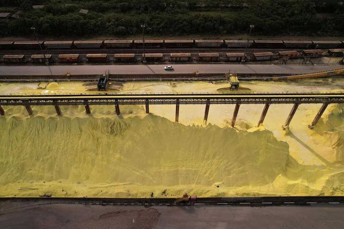 A car passes between imported sulphur used in fertilisers and a cargo train at TIPLAM (Integrator Port Terminal Luiz Antonio Mesquita) from VLI Multimodal S.A. at Santos port, in Santos on Brazil May 25, 2023. 