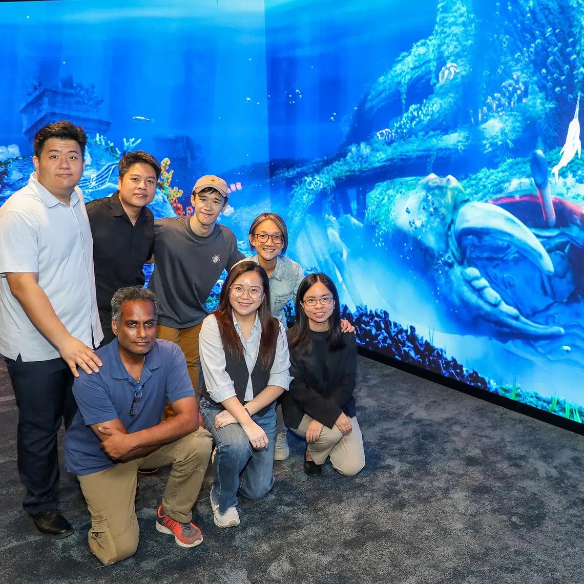 kgglass - ST20250723_202554900456. Luther Lau. Group pix of Standing (top from left): Ash Mo Naiming, Systems Integration Manager Brian Gothong Tan, Creative Director Joshua Tan, Multimedia Director Priscilla Chua, Principal Curator at National Museum of Singapore (Bottom row:) Subash Chakrapani, Project Manager, Melissa Chan Art and Design Director, Jan Yap, Assistant Curator,  National Museum of Singapore with one of their showcases for content in the newly revamped Glass rotunda. Taken at the National Museum of Singapore.