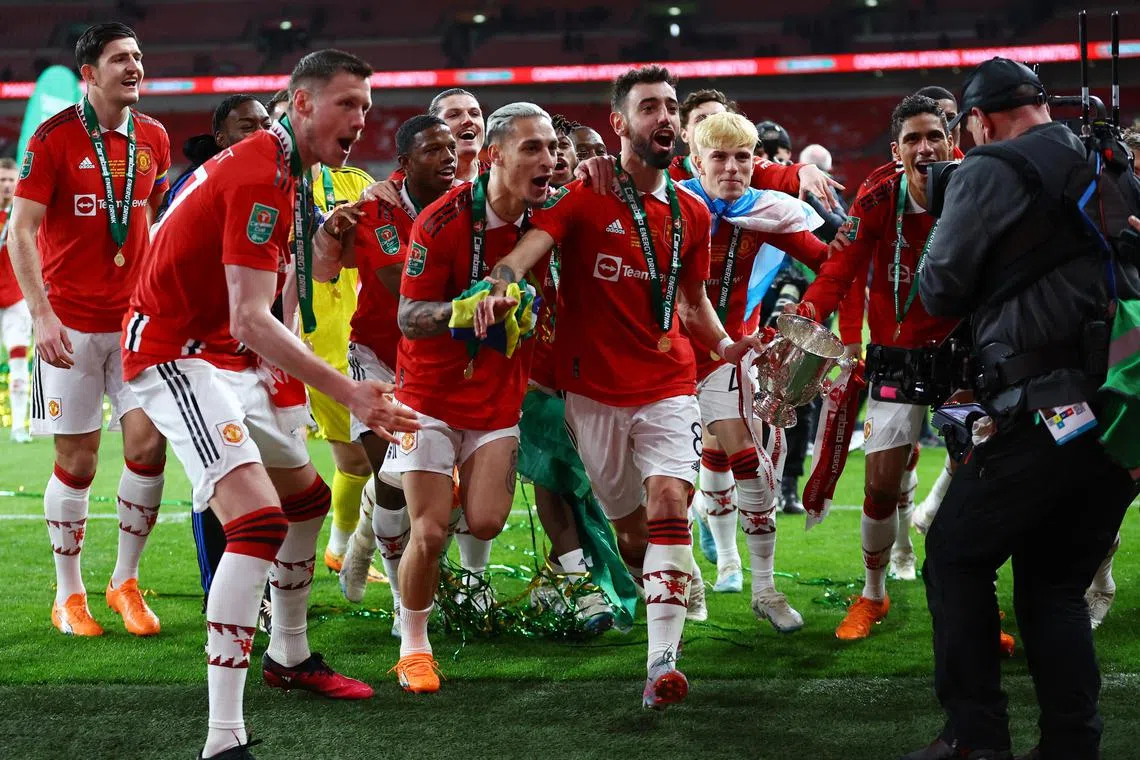 Manchester United players celebrating after beating Newcastle to win the League Cup.