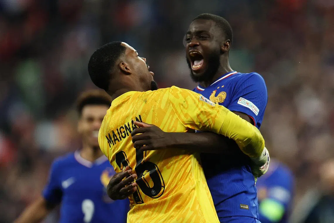 Soccer Football - Nations League - Quarter Final - Second Leg - France v Croatia - Stade de France, Saint-Denis, France - March 23, 2025 France's Dayot Upamecano celebrates with Mike Maignan after scoring the winning penalty in the shootout REUTERS/Sarah Meyssonnier