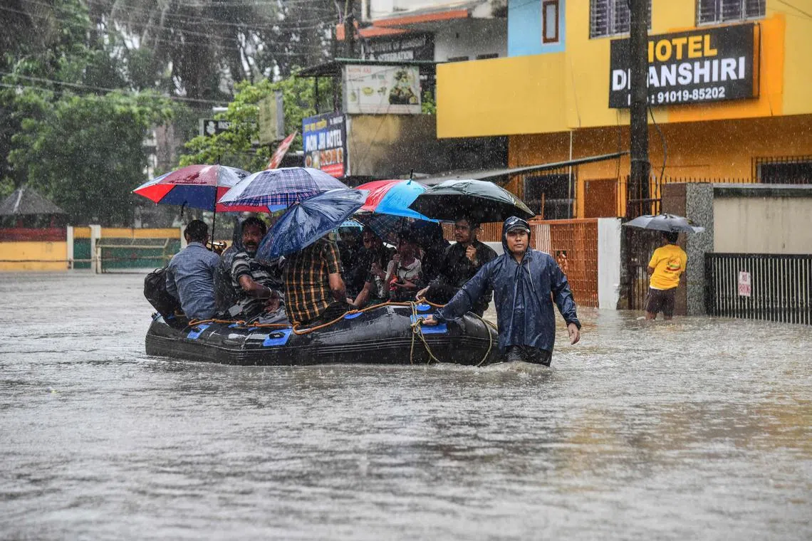 A State Disaster Response Fund (SDRF) personnel rescue residents from a flooded area after heavy rainfall in Guwahati, in India's state of Assam on May 30, 2025. (Photo by Biju BORO / AFP)