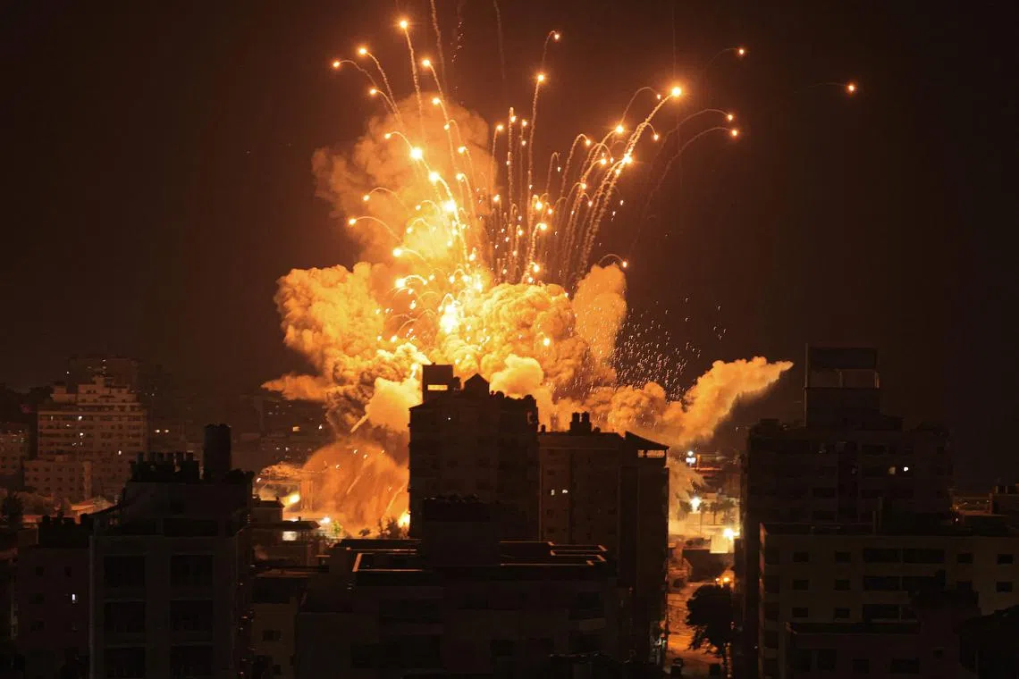 A missile explodes in Gaza City during an Israeli air strike on Oct 8. 