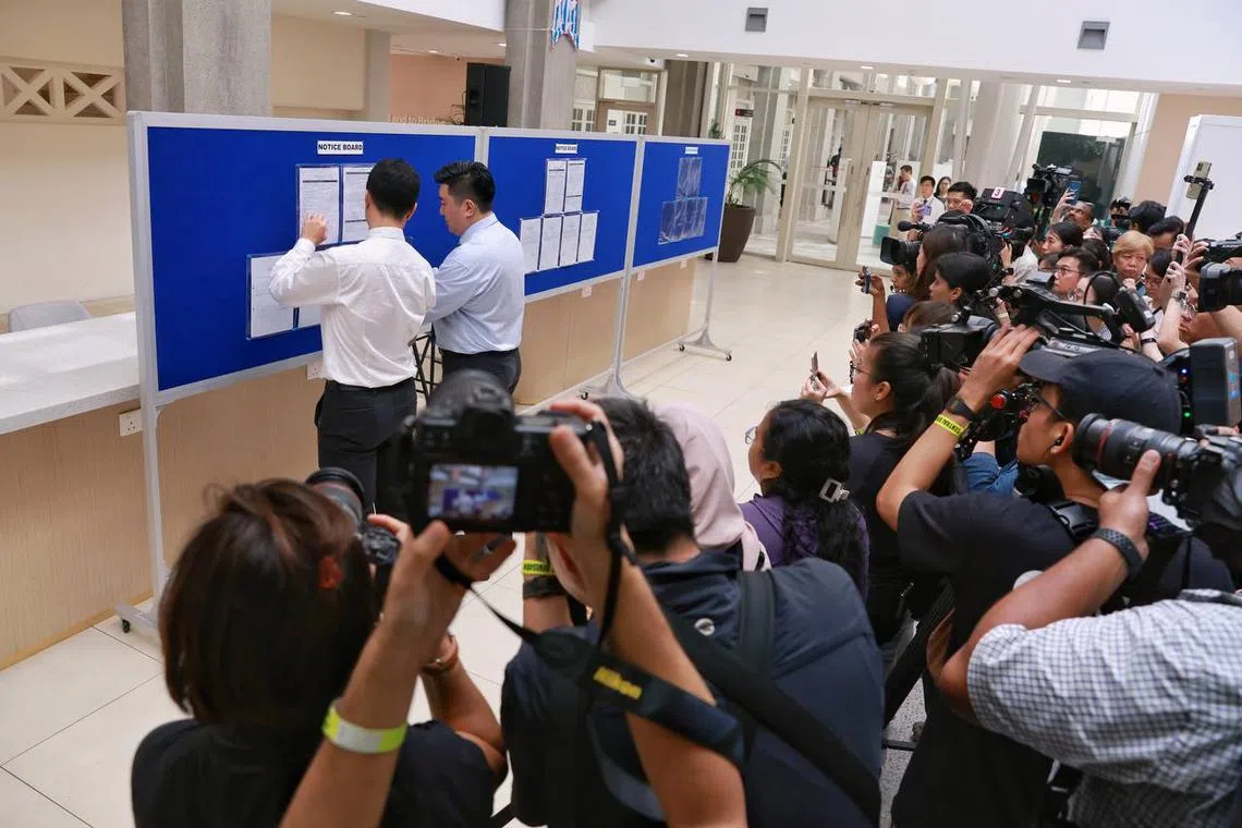 Elections officials updating presidential candidate Tharman Shanmugaratnam’s nomination papers with the logo of pineapple on the notice board at the nomination centre. 