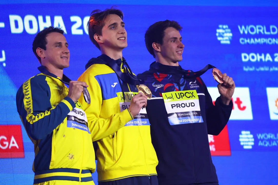 Ukraine's gold medal winner Vladyslav Bukhov (centre) celebrates on the podium with silver medallist Cameron McEvoy, of Australia, and British bronze medallist Benjamin Proud.