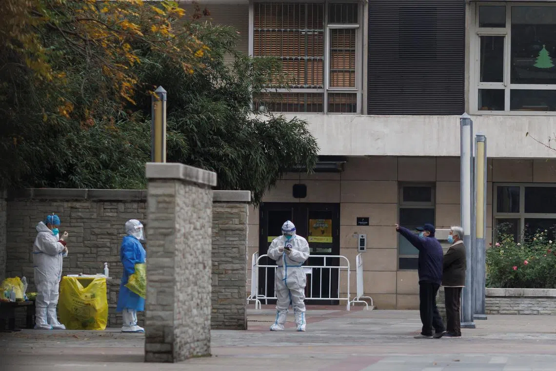 Residents talk to pandemic prevention workers in an apartment that was under lockdown in Beijing on Nov 9, 2022.