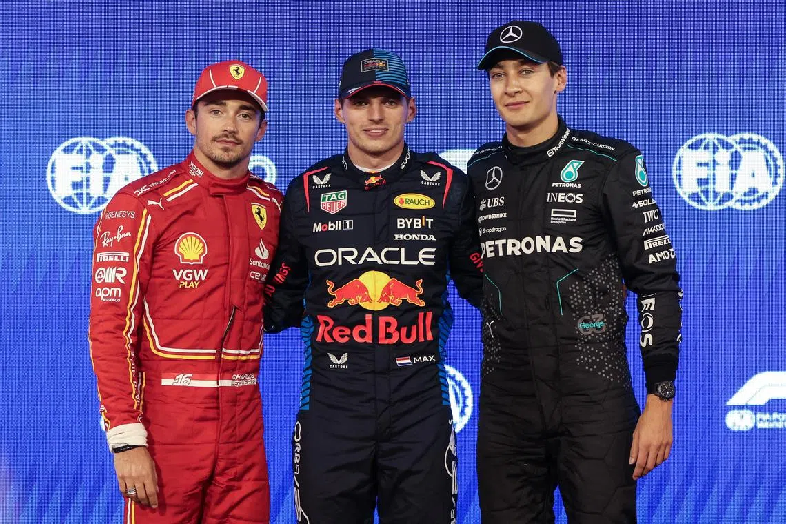 Red Bull's Max Verstappen (centre) celebrates pole position with Ferrari's Charles Leclerc (left), who takes the second spot on the grid, and Mercedes' George Russell, who is in third.