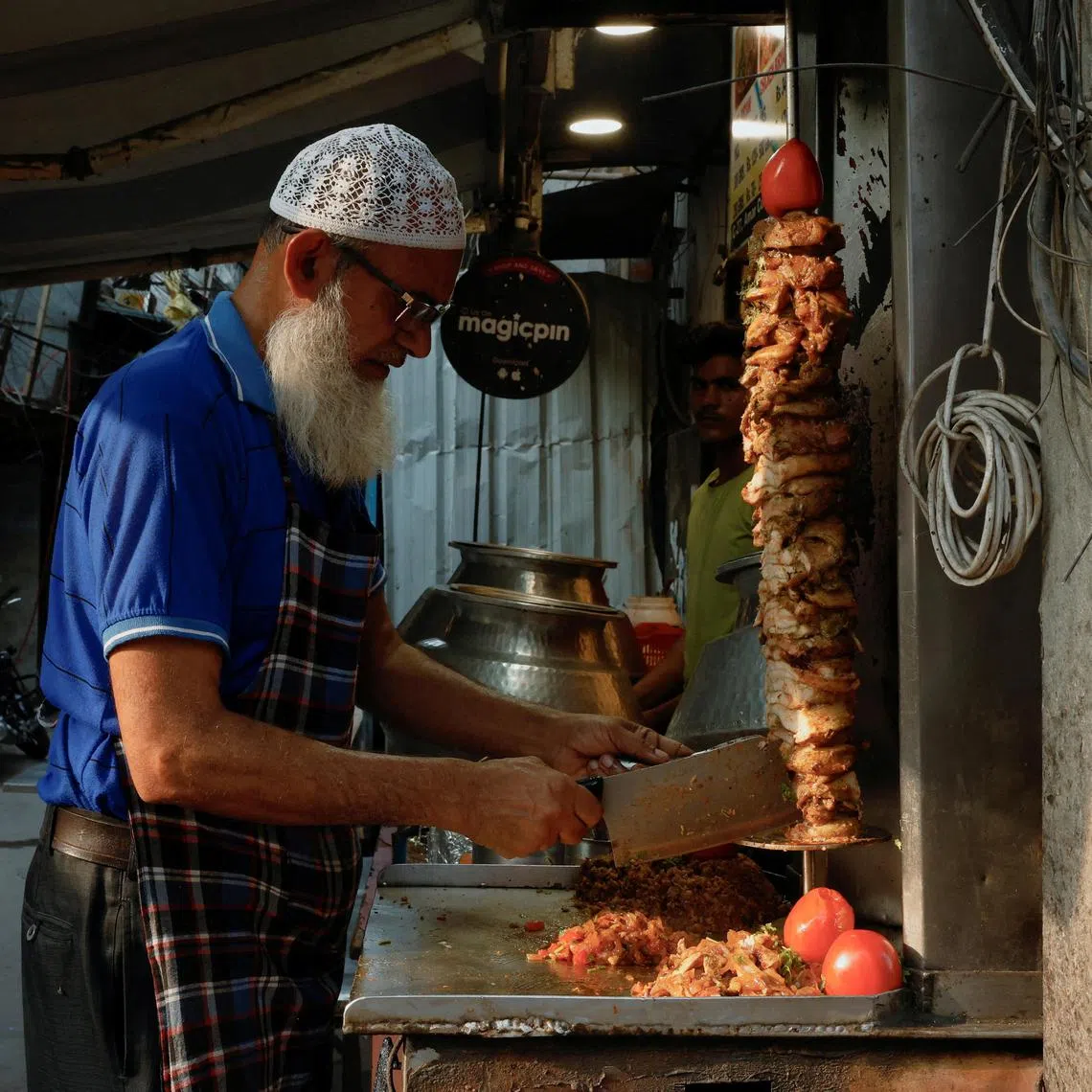 A chef slices shawarma at a roadside food stall in New Delhi.