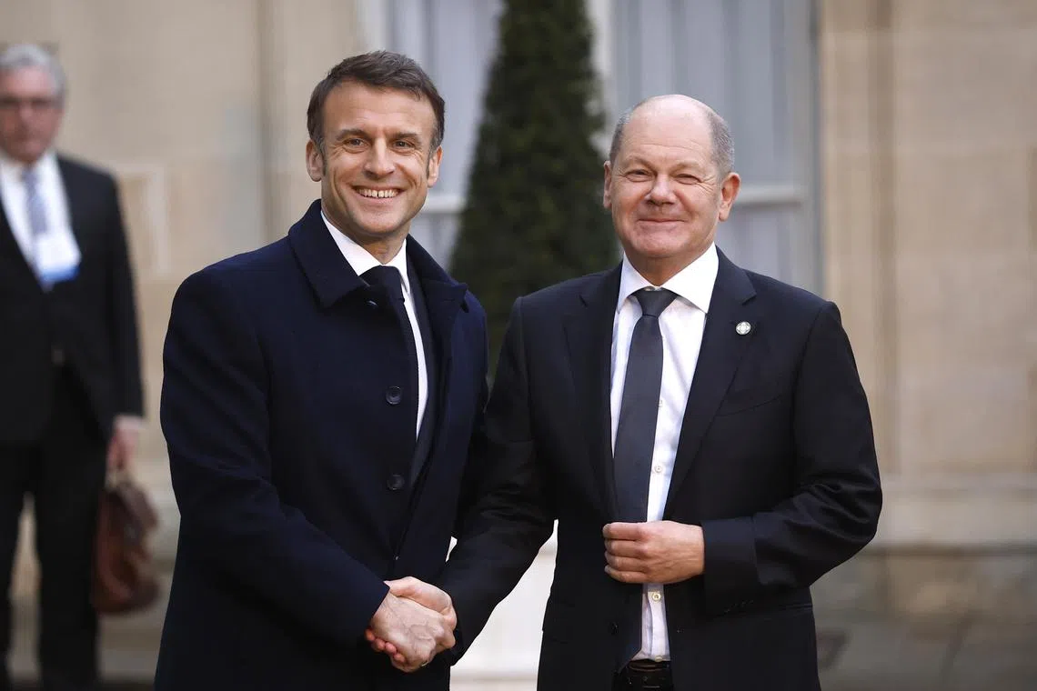 epa11183049 French President Emmanuel Macron (L) greets German Chancellor Olaf Scholz (R) upon his arrival at the Elysee Palace to attend the international conference in support of Ukraine in Paris, France, 26 February 2024.  EPA-EFE/YOAN VALAT