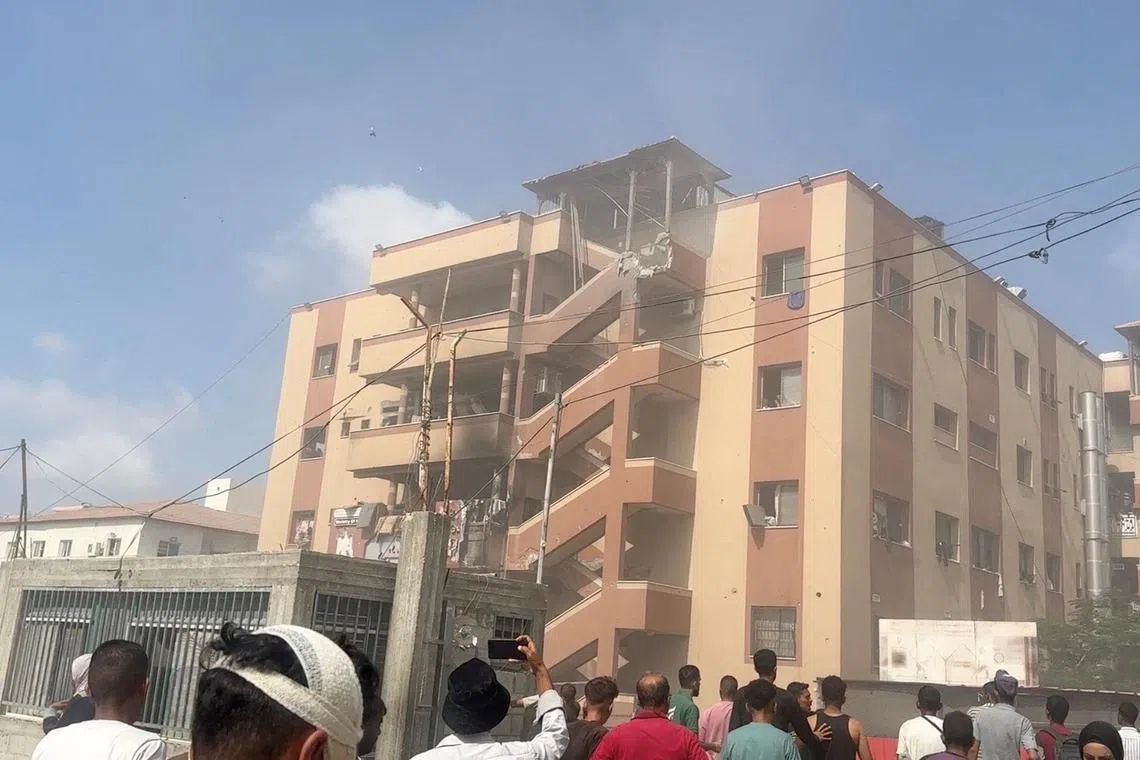 People walk at the site of Israeli strikes on Nasser hospital, in Khan Younis in the southern Gaza Strip in this still image taken from video, on Aug 25, 2025.