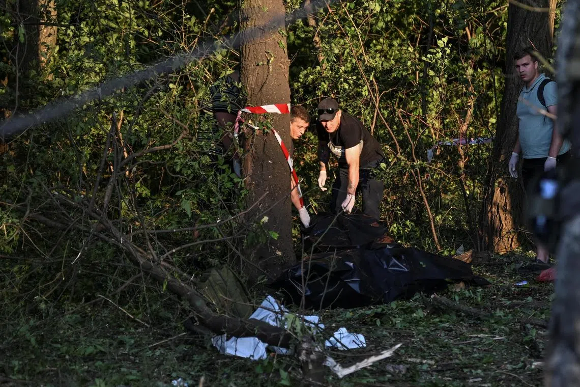 Ukrainian officials inspect the bodies of people killed by a Russian missile strike in the city of Zaporizhzhia.  