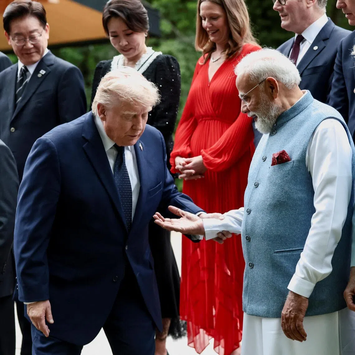 India's Prime Minister Narendra Modi offers a hand to US President Donald Trump (left) during a family photo at the G-7 summit, in Evian-les-Bains, France.